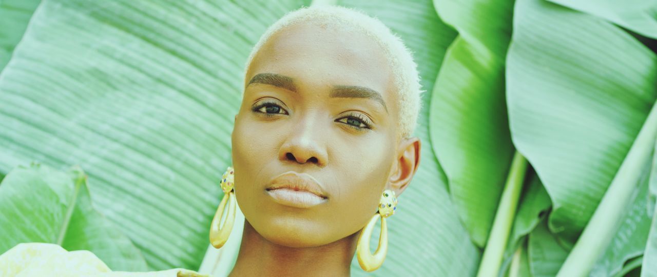 leaf, portrait, plant part, headshot, green color, plant, close-up, young adult, one person, front view, young women, leisure activity, day, real people, lifestyles, looking, women, nature, focus on foreground, beautiful woman, outdoors, leaves, human face, contemplation, palm leaf