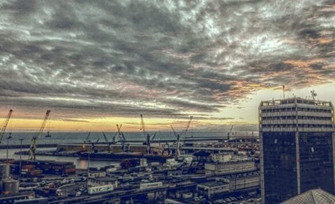 View of cityscape against cloudy sky