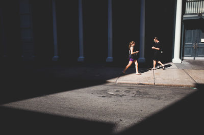 Woman walking on footpath in city