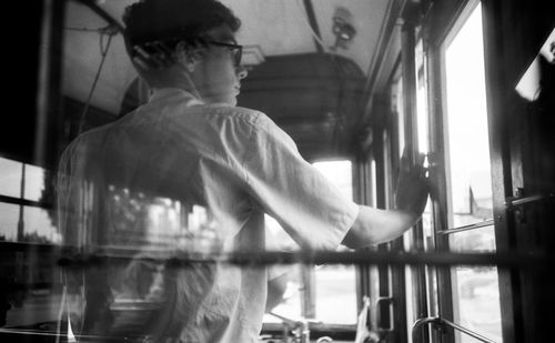 Man sitting on railing by window