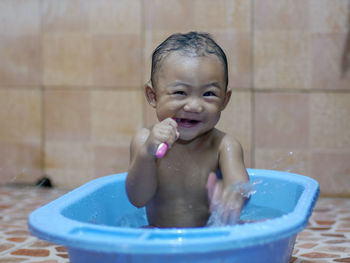 Portrait of shirtless baby boy in bathroom