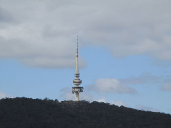 Communications tower against cloudy sky