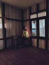 Woman sitting in abandoned building