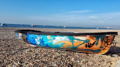Boats moored on beach against sky