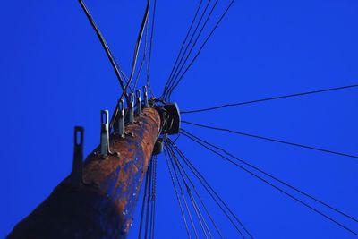 Low angle view of cables against clear blue sky