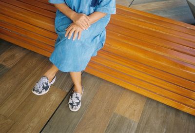 Low section of woman sitting on hardwood floor