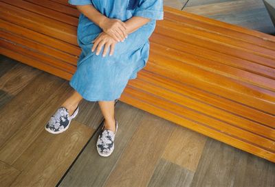 Low section of woman walking on wooden floor