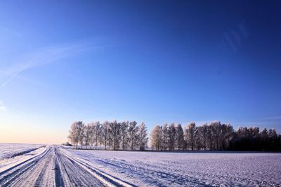 Snow covered street during winter against clear blue sky