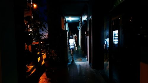 People walking in illuminated corridor