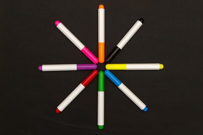 High angle view of colored pencils on table against black background
