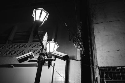 Low angle view of illuminated lighting equipment hanging from ceiling