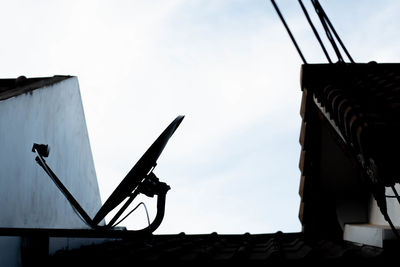 Low angle view of silhouette crane against clear sky