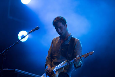 People playing guitar at music concert