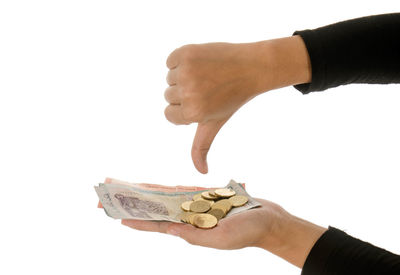 Close-up of hand holding cigarette against white background