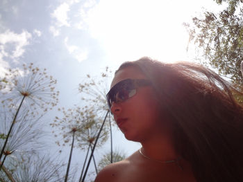 Portrait of young woman wearing sunglasses against sky