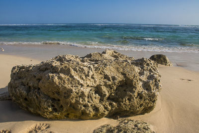 Scenic view of rocks on beach against sky