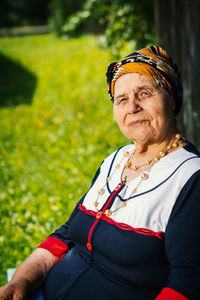 Portrait of senior woman sitting in yard