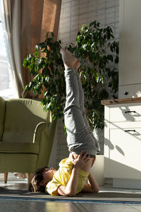 Little boy practicing yoga, stretching, fitness at home. distant online education training at home.