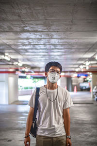 Portrait of young man standing wearing mask standing in parking lot