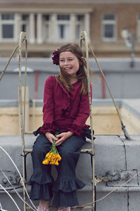 Girl looking away while sitting on railing