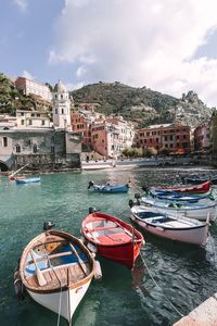 Boats moored in sea against buildings in city