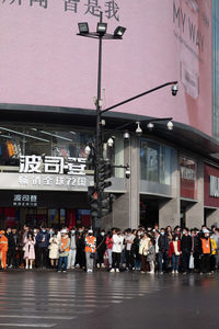 People walking on street against buildings in city