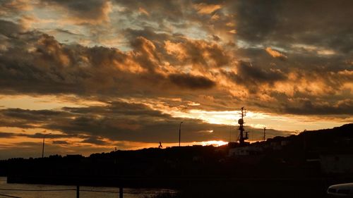 Silhouette of tower against dramatic sky during sunset