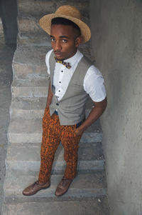 Portrait of young man standing against wall