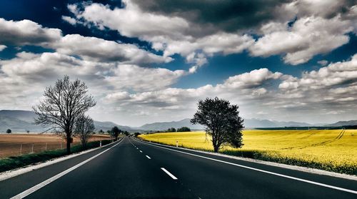 Empty road along countryside landscape