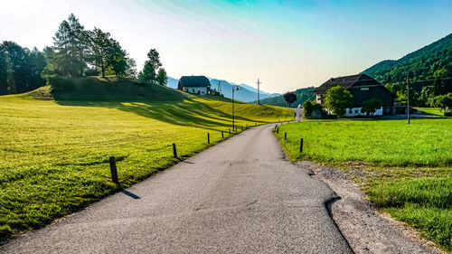 Road amidst field against sky