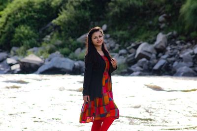 Portrait of smiling young woman standing on land