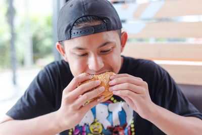 Boy eating hamburger.