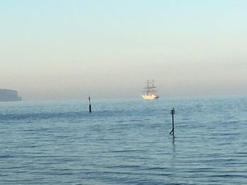 Sailboat sailing on sea against clear sky