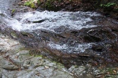 High angle view of stream flowing through rocks
