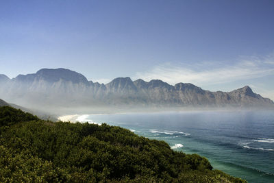 Scenic view of sea and mountains against clear sky