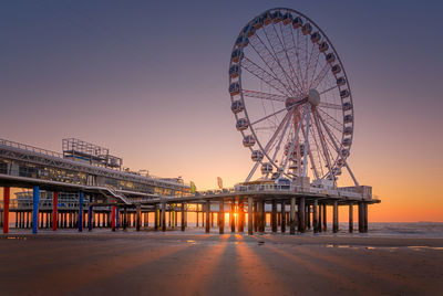 Ferris wheel at beach against clear sky