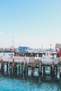 Boats moored in harbor against clear sky