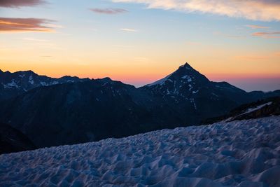 Scenic view of snowcapped mountains against sky during sunset