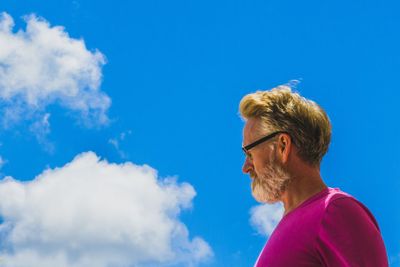 Low angle view of man wearing sunglasses against sky