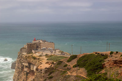 Fort at seaside of portugal, nazare. lighthouse on the rocky cliff