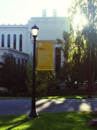 Street light by building in city against sky