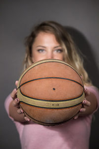 Portrait of a beautiful young woman holding ball