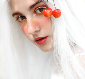 Close-up portrait of young woman with by cherries