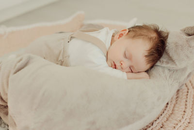 Cute baby girl sleeping on bed at home