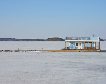 Building by sea against clear sky