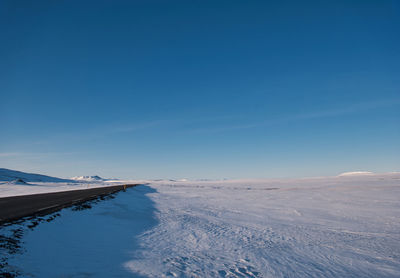 Scenic view of snowcapped mountains against blue sky