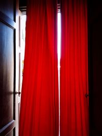 Close-up of red curtain against window