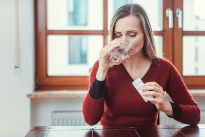 Portrait of a young woman drinking glass