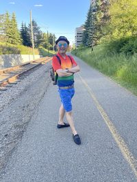 Full length portrait of man standing on road