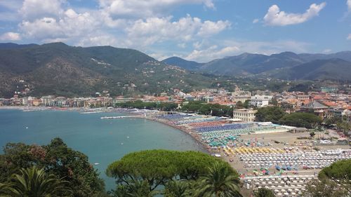 Aerial view of town by sea against sky